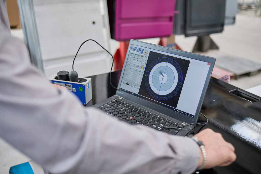 Eine Person bedient einen Laptop, auf dem ein technisches Kreisdiagramm mit Messdaten, wahrscheinlich für industrielle oder technische Zwecke, an einem Arbeitsplatz angezeigt wird. LAC Berger Industrielackierung